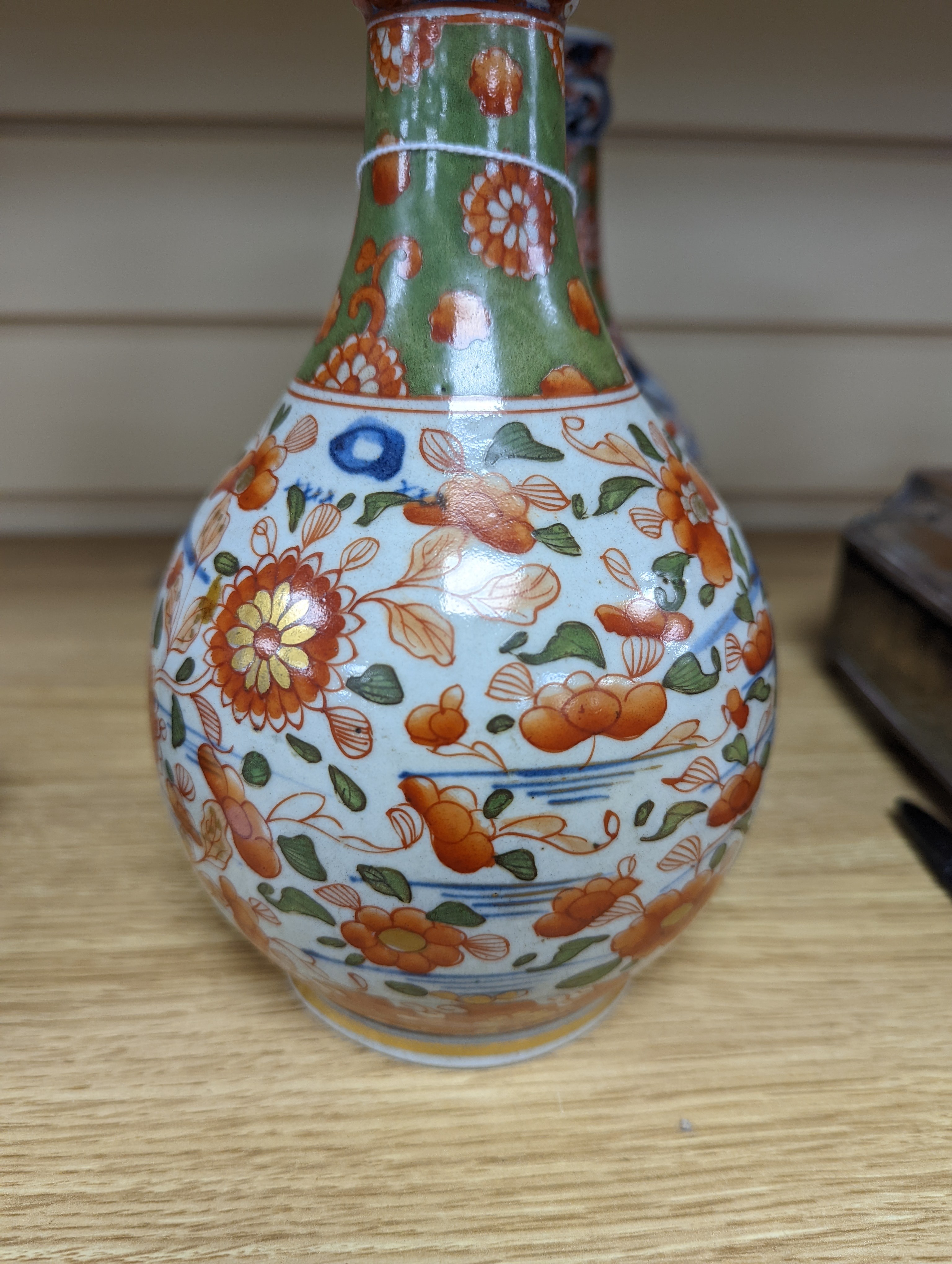 A pair of 18th century Chinese clobbered blue and white bottle vases 23cm